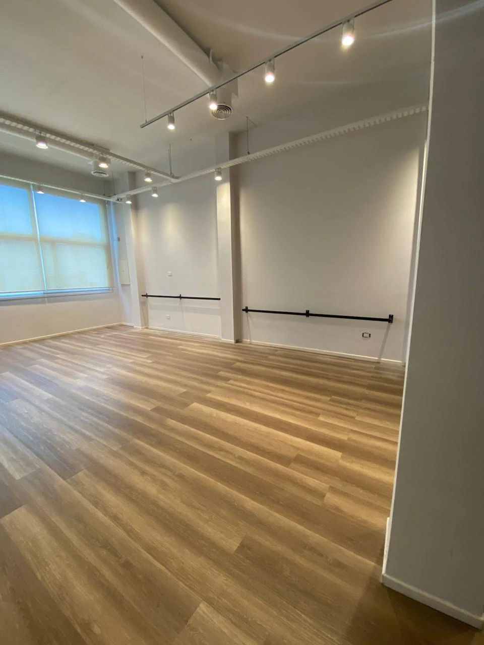 Salón de danza con barras y piso de madera