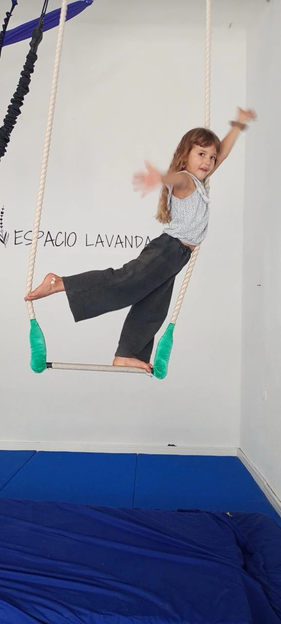 Nena parada en el trapecio